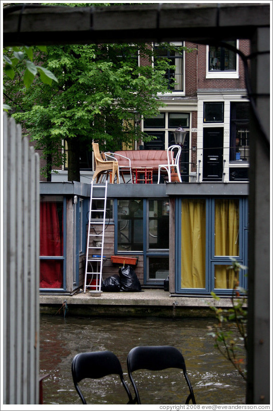 Houseboat with furniture on top, Prinsengracht canal, Jordaan district.