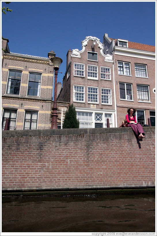 Barefoot woman enjoying the sun by a canal.  Leidsegracht, Jordaan district.