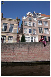 Barefoot woman enjoying the sun by a canal.  Leidsegracht, Jordaan district.