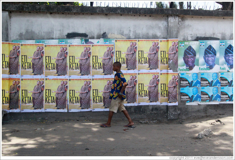 Man walking in front of posters that say Eti Keta and Reelect Fasholm.