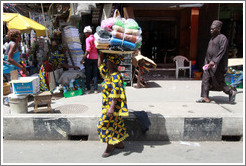 Woman with a bundle of cloths on her head.