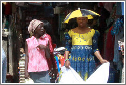 Two women talking. One wears an umbrella hat.