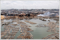 Timber being dried with fire. Makoko, a slum on the Lagos Lagoon.