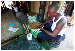 Artist constructing something at the market. Victoria Island.