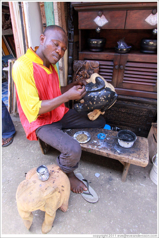 Artist constructing something at the market. Victoria Island.