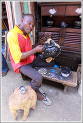 Artist constructing something at the market. Victoria Island.