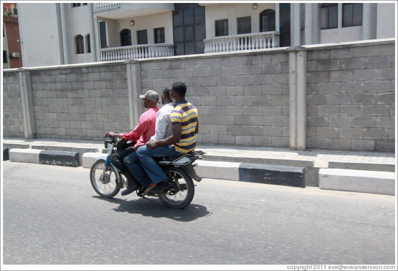 Three men on a motorcycle. Maroko Road, Victoria Island.