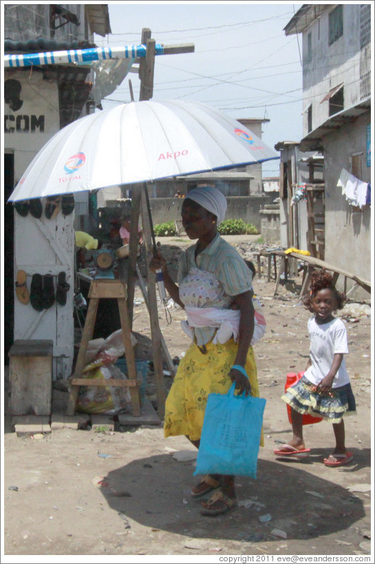 Women under umbrella and girl.