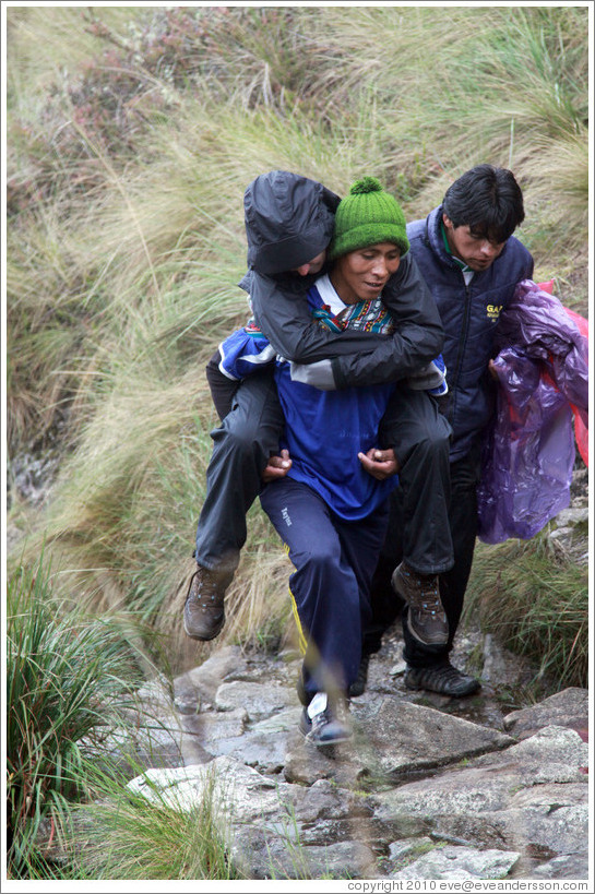 Sick woman carried by a porter on the Inca Trail.