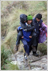 Sick woman carried by a porter on the Inca Trail.