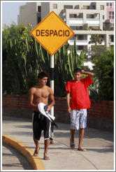 Boys standing near a "Despacio" sign, El Malec?Miraflores neighborhood.