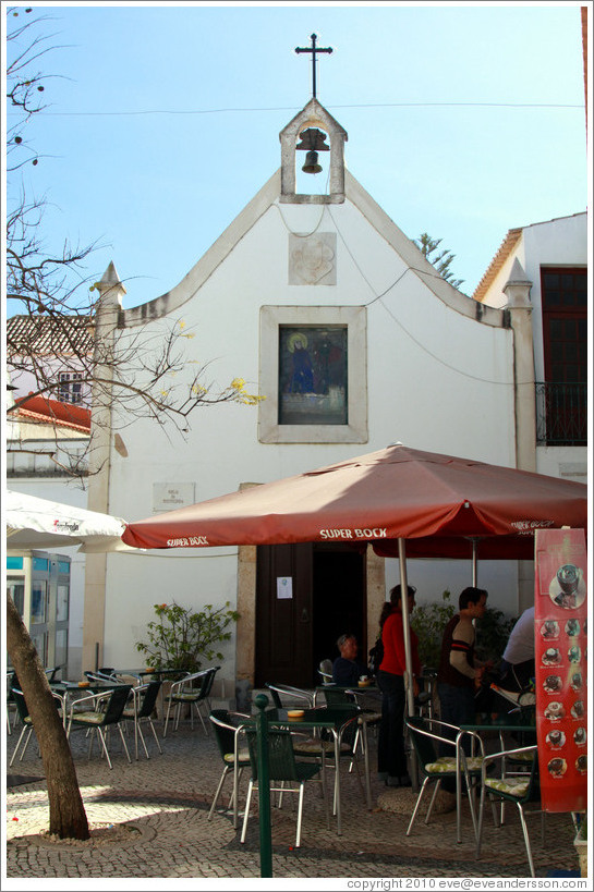 Igreja da Miseric?a (Church of Mercy) behind a pub with umbrellas advertising beer.