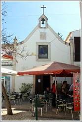 Igreja da Miseric?a (Church of Mercy) behind a pub with umbrellas advertising beer.