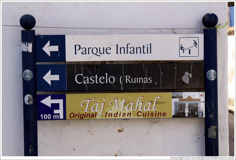 Sign reading Parque Infantil (playground), Castelo Ruinas (castle ruins), and Taj Mahal Original Indian Cuisine.