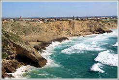 Cliff with a sea cave, with the town of Sagres behind.