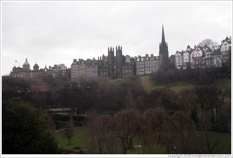 Princes Street Gardens on an overcast day.  In the background are buildings designed by Sir Patrick Geddes in 1893 and other Old Town buildings.