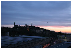 Edinburgh Waverley railway station's roof, with Calton Hill in the background, at sunrise.