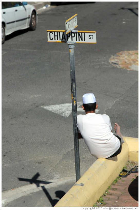 Man resting against street sign, Bo-Kaap.
