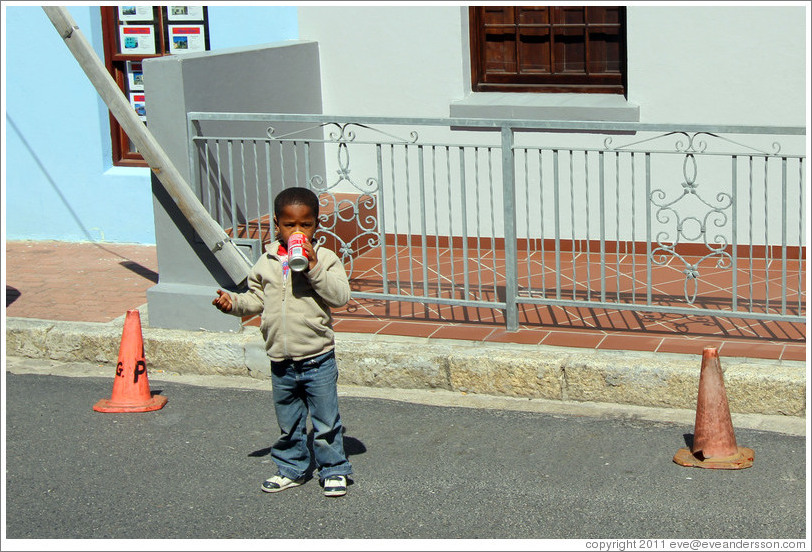 Boy drinking a can of Coke. Chiappini Street, Bo-Kaap.