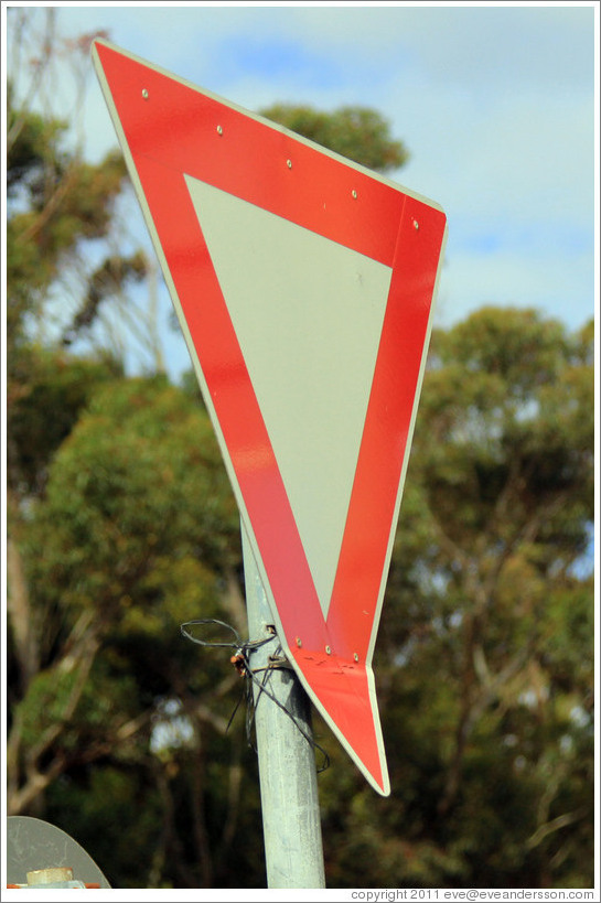 Yield sign with a bent corner. Corner of Slangkop Road and Kommetjie ...