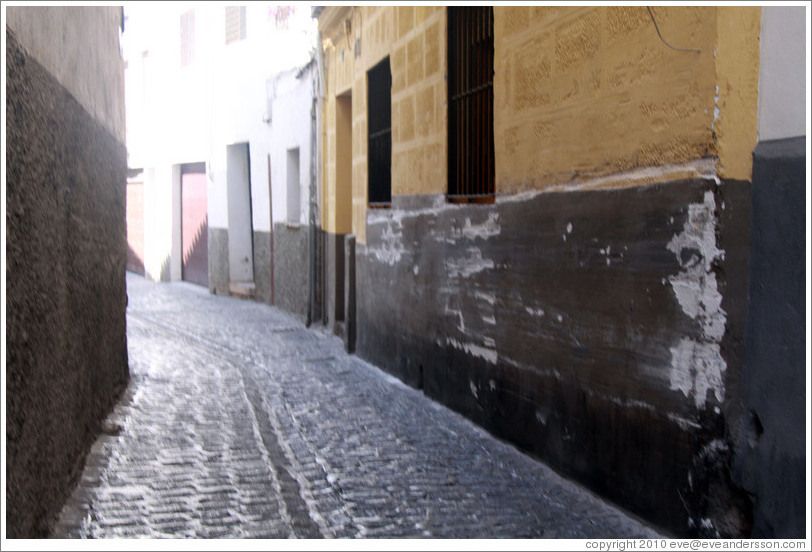 A very narrow portion of Calle de San Juan de los Reyes, Albaic? The wall has been scraped up by cars that pass too close.