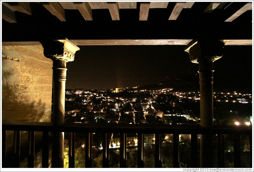 Balcony in Nasrid Palace, Alhambra overlooking Granada at night.