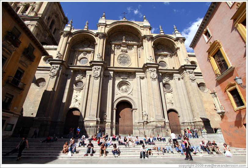 People enjoying the sun on steps in from of the Granada Cathedral.