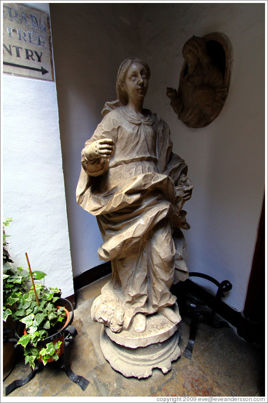 Statue of innocent-looking woman standing next to decapitated man's head.  Granada Cathedral.