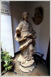 Statue of innocent-looking woman standing next to decapitated man's head.  Granada Cathedral.