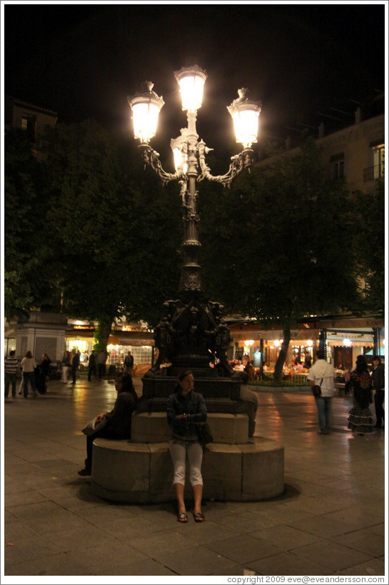Girl sitting under lights.  Plaza de Bib-Rambla.  City center.