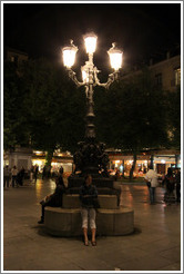 Girl sitting under lights.  Plaza de Bib-Rambla.  City center.