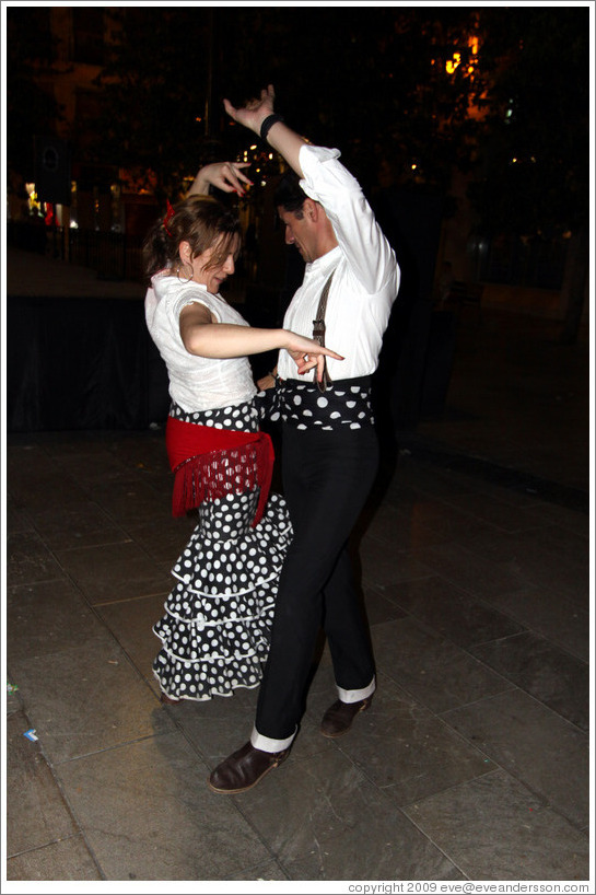 Woman and man dancing flamenco on the street at night during the Fiesta de las Cruces.  Plaza del Carmen.  City center.