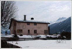 Romansh building, with mountains behind.