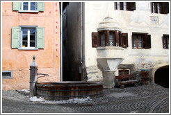 Fountain, with Romansh buildings behind.