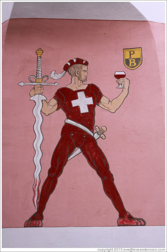 Swiss man with swords and a glass of wine, painted on the side of a building.