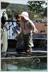Baby drinking from fountain.  Clean, mountain water comes out of fountains in Z?rich.  Lindenhof.  Altstadt (Old Town).