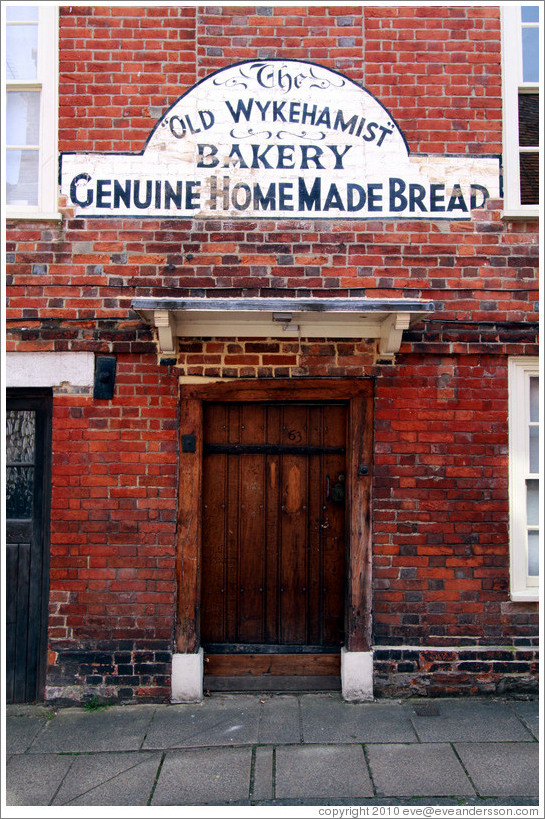 Old sign painted onto a brick wall, reading "Old Wykehamist Bakery / Genuine Home Made Bread".  Canon St.