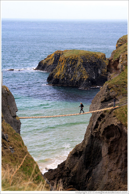 Man crossing Carrick-a-Rede Rope Bridge.