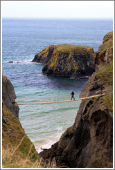 Man crossing Carrick-a-Rede Rope Bridge.