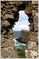 View of a sea cliff through a hole in the wall of Dunluce Castle.