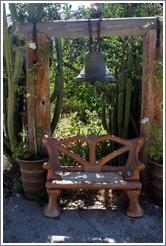 Bell and bench in garden.  San Juan Bautista Mission.