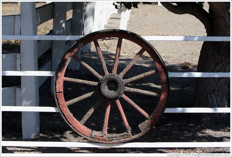 Wagon wheel on fence.  Tres Hermanas Winery.