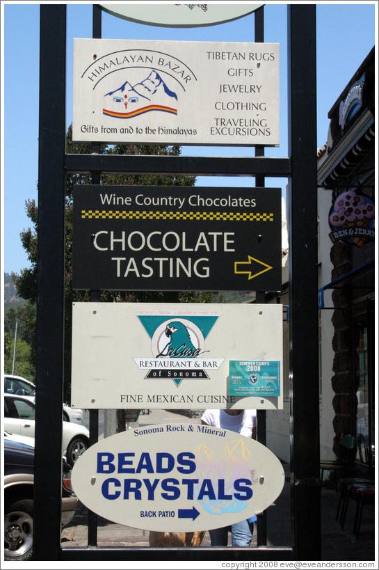 Business signs in downtown Sonoma: Chocolate Tasting, Crystals, and Himalayan products.