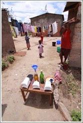 Kids standing behind Mealie Meal (a maize flour) and cooking oil.  Garden District.