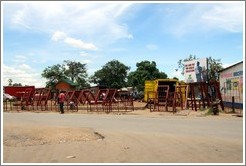 Construction materials for sale on the roadside.  Billboard reads: "Use and pay for waste collection."